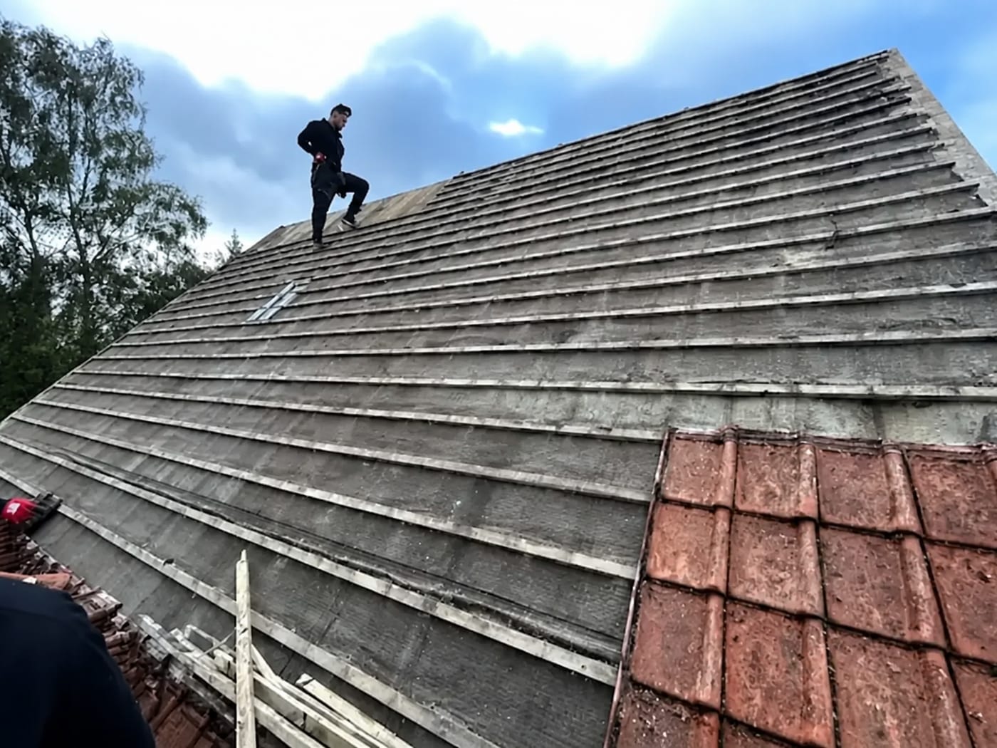 A CAW roofer stripping and re-battening a tiled roof on a Reading home